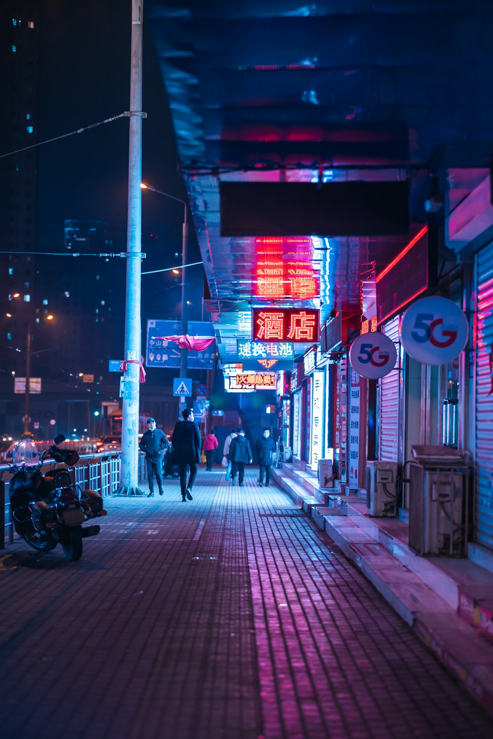 people walking on sidewalk during night time