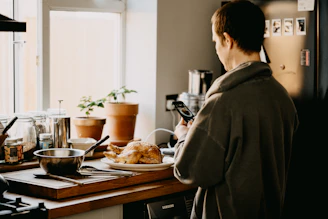 man in gray coat standing in front of table with food