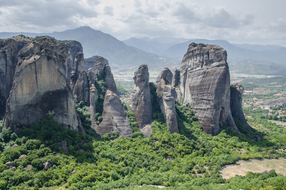 green trees and brown rocky mountain under white clouds during daytime