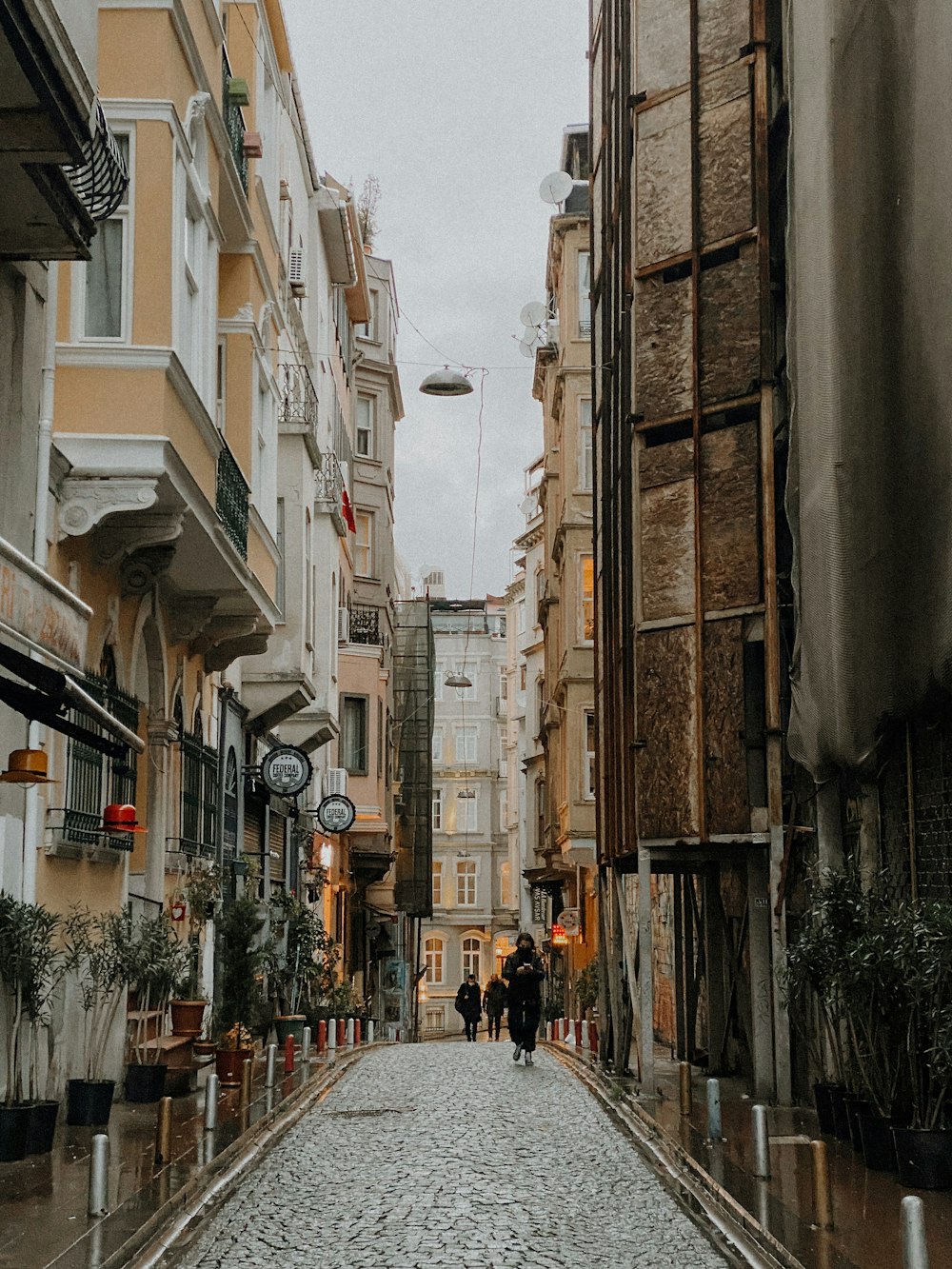 pessoas andando na rua entre os edifícios durante o dia