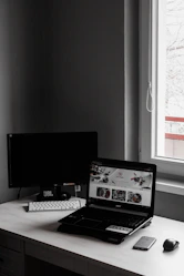 A minimalist workspace with a laptop displaying a sleek website design.