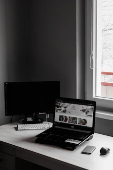 A minimalist workspace with a laptop displaying a futuristic web design interface.