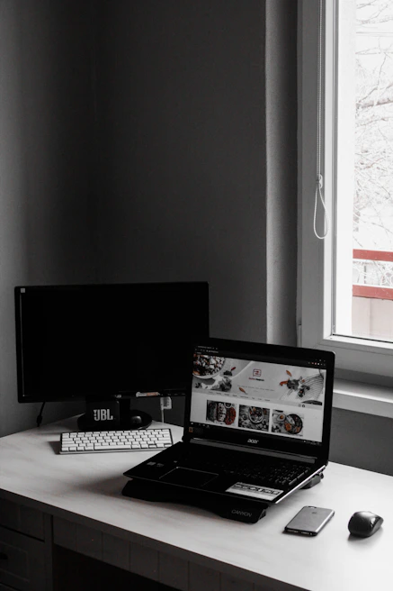 Minimalistic workspace featuring a laptop displaying a portfolio page with crisp typography
