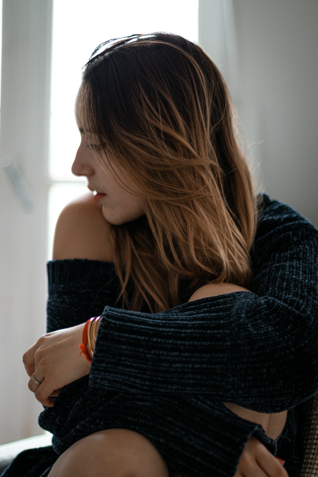 woman in black sweater holding her hair