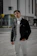 A stylish young man confidently wearing a sleek black auravibe jacket in an urban setting.