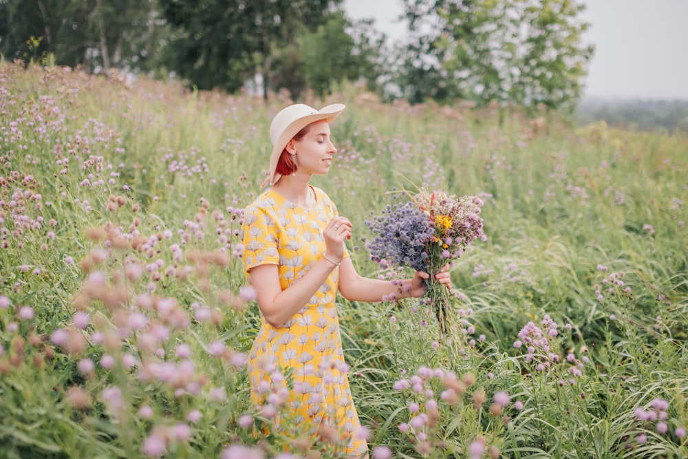 girl in yellow and white floral dress holding flower