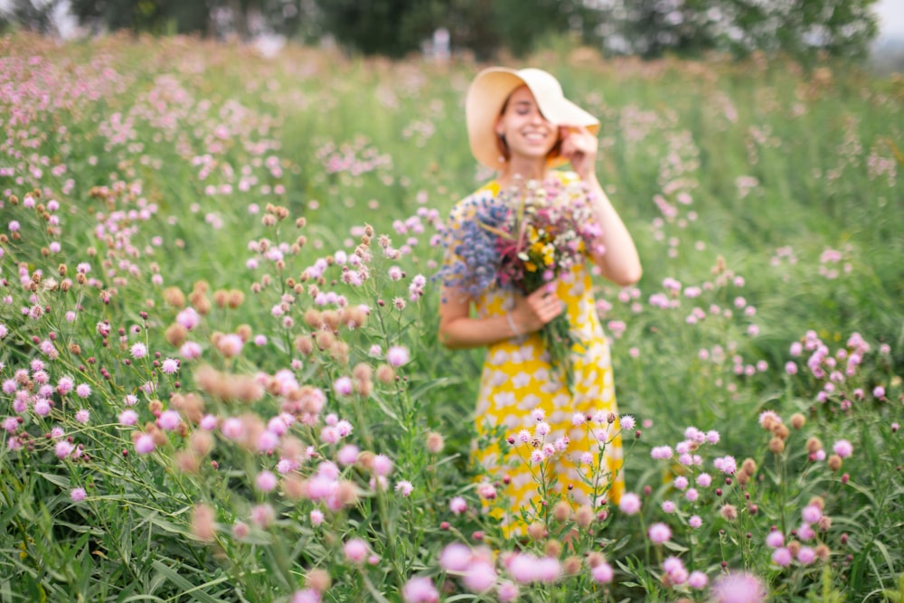 ragazza in abito floreale giallo e bianco in piedi sul campo di fiori durante il giorno