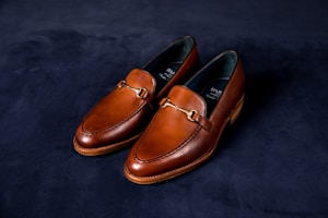 Handcrafted leather shoes with minimalist design and gold accents reflecting African heritage.