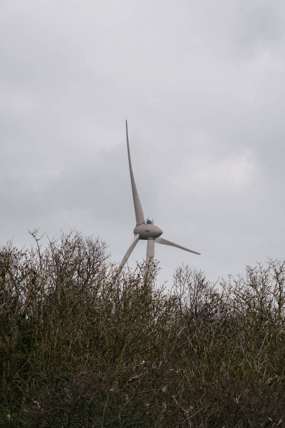 white windmill on green grass field under gray cloudy sky