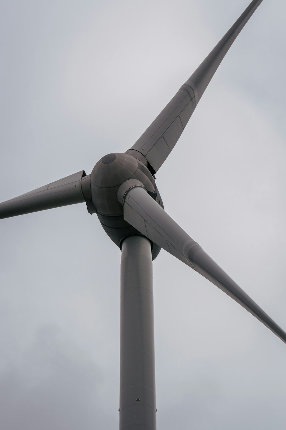 white wind turbine under white sky during daytime