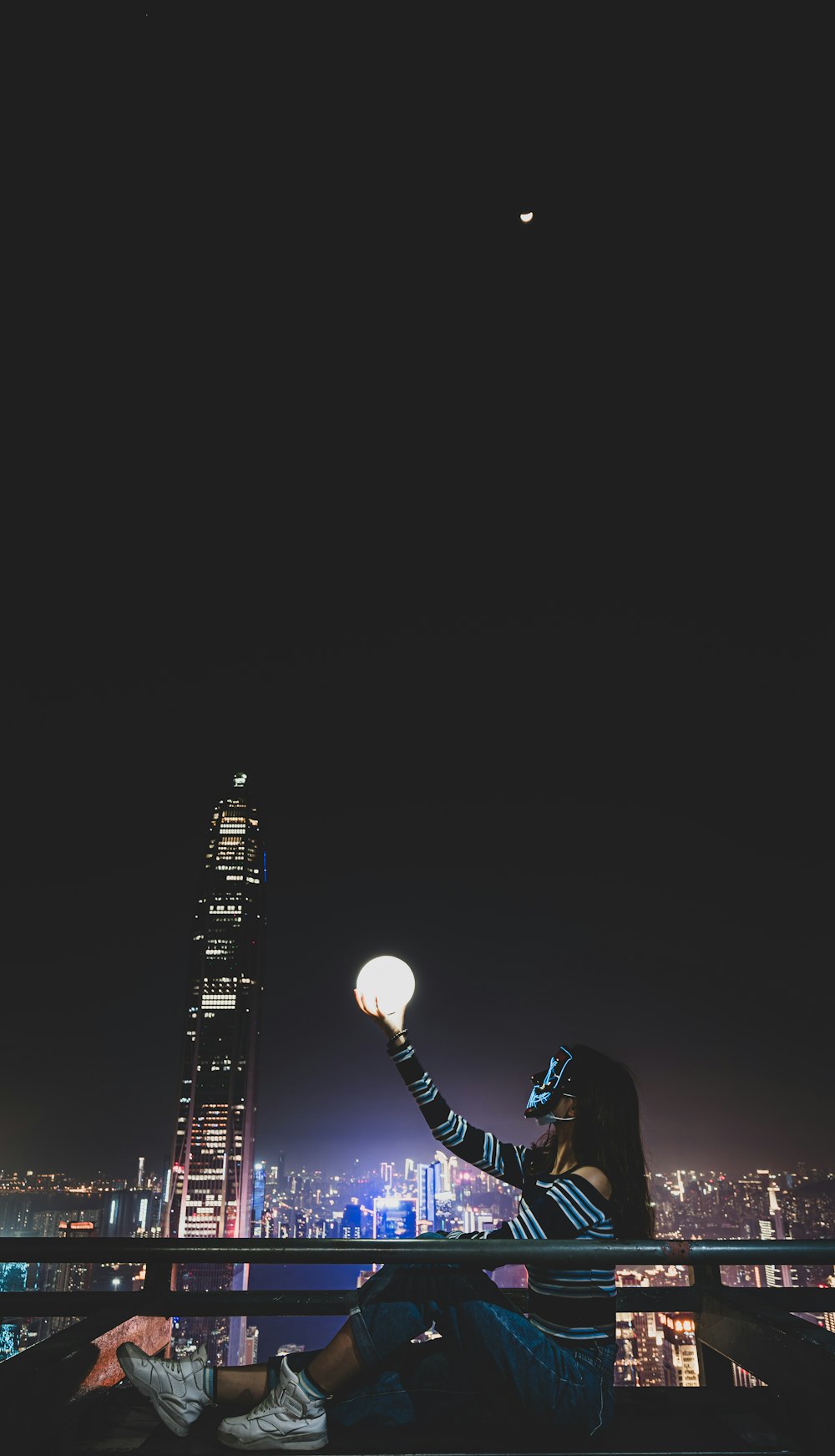 man in black shirt holding white light bulb