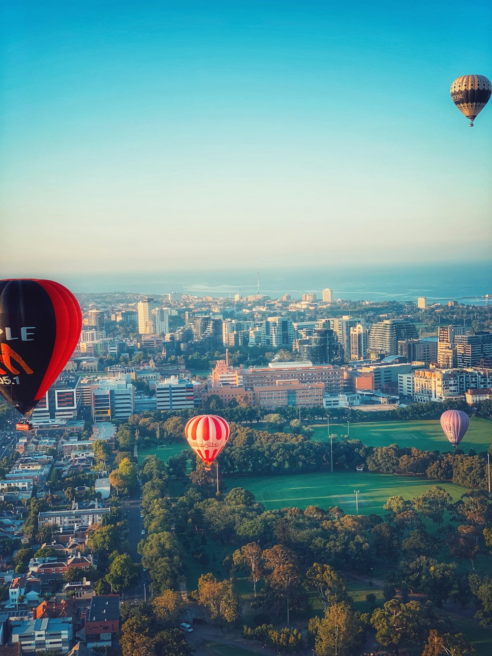 red hot air balloon over city buildings during daytime