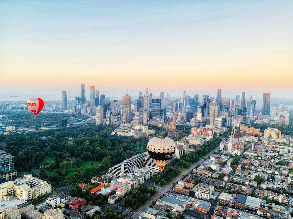 hot air balloons over city buildings during daytime