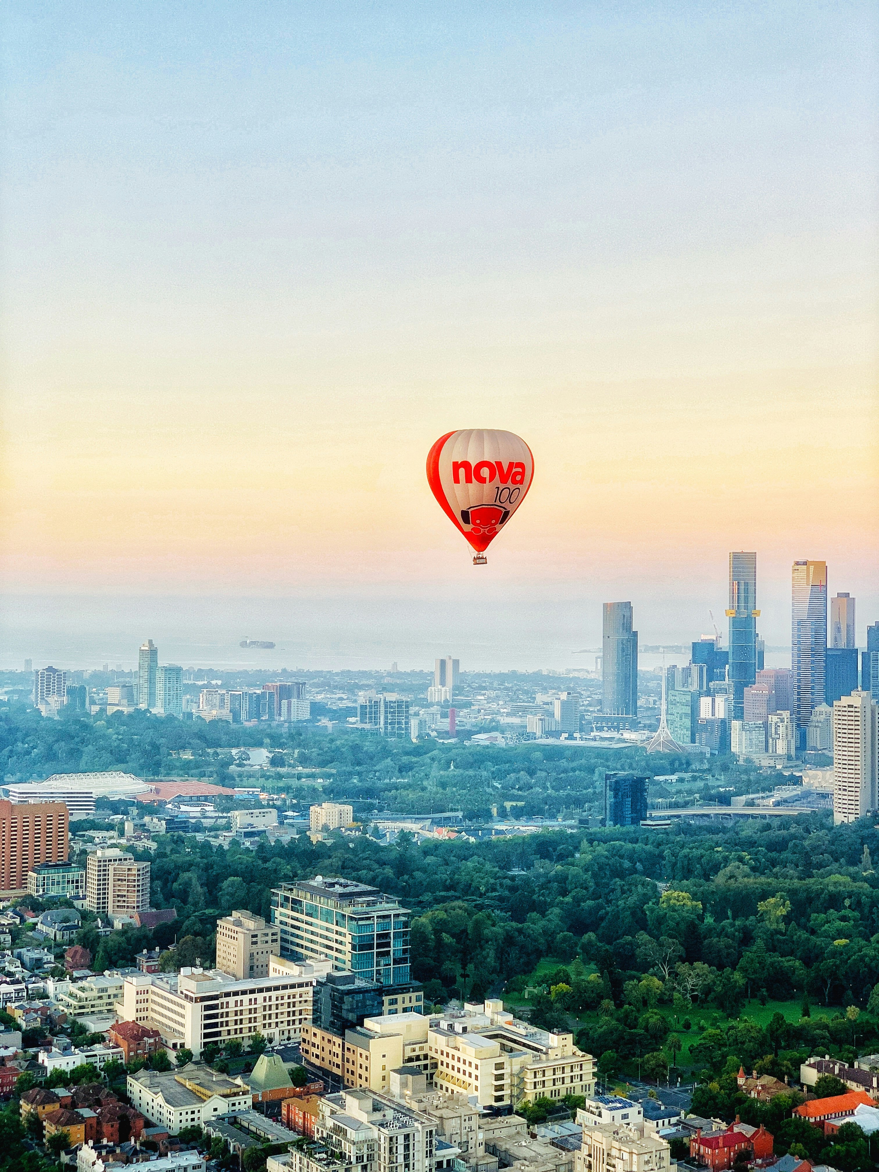 red and black hot air balloon over city buildings during daytime