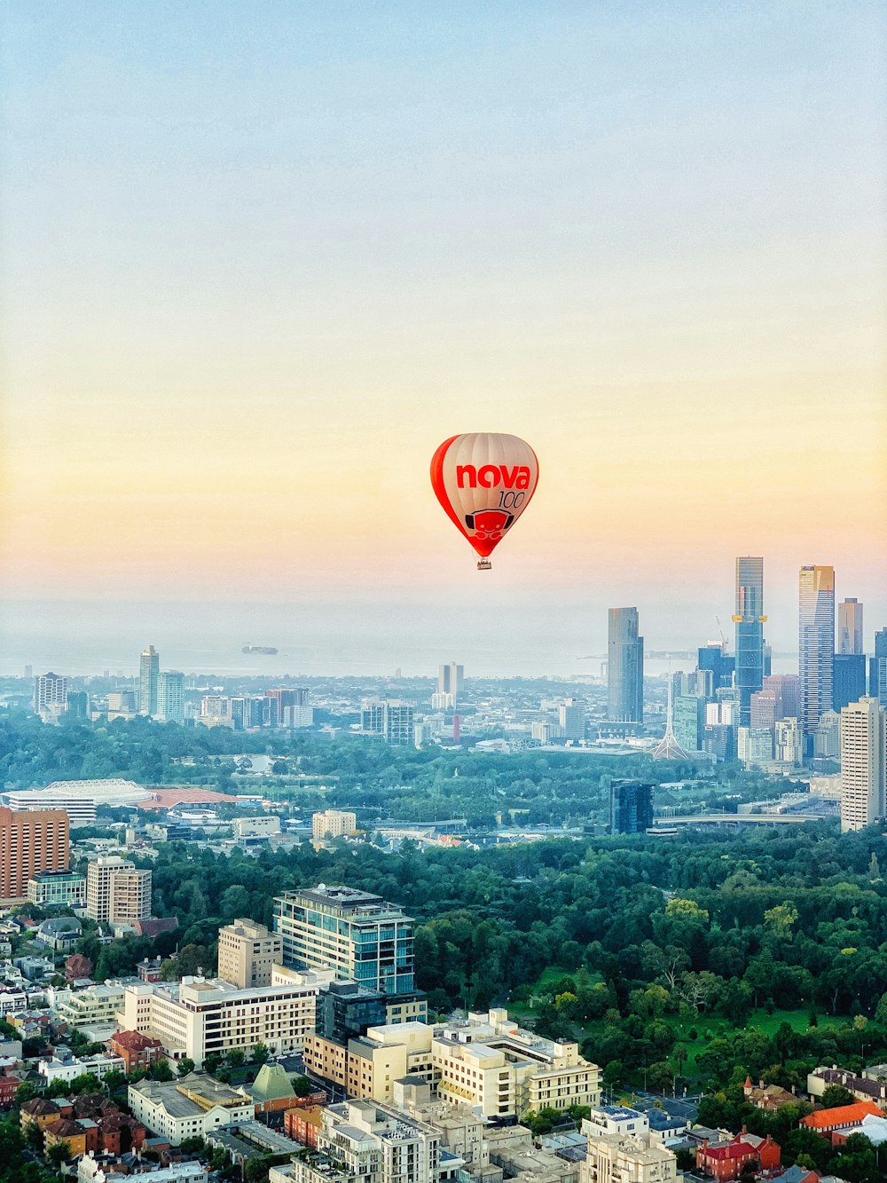 red and black hot air balloon over city buildings during daytime