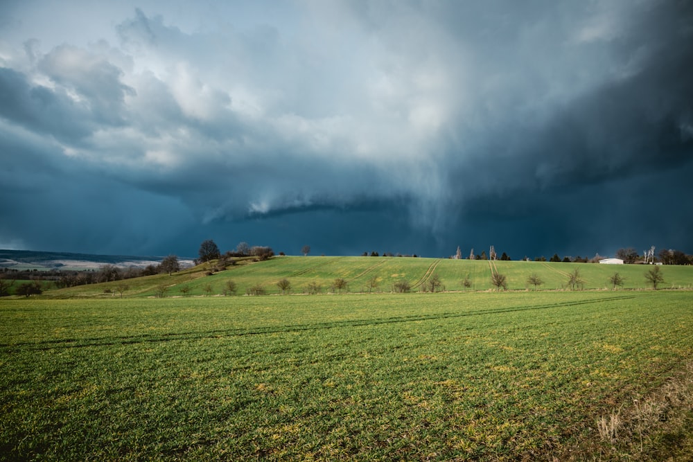 green grass field under white clouds during daytime