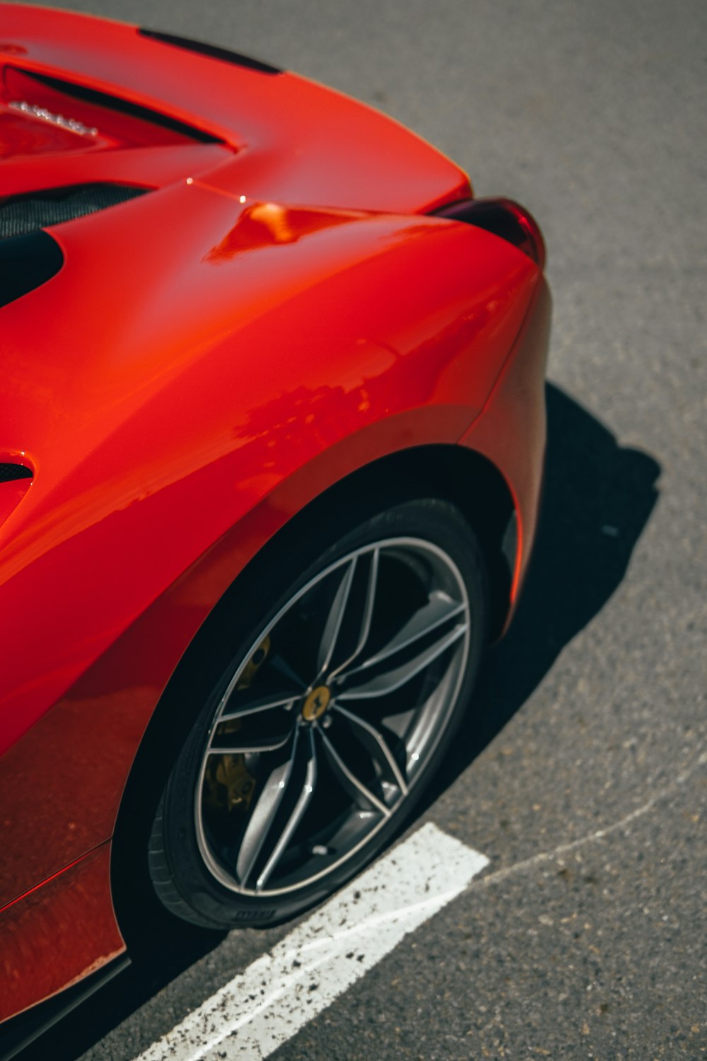 red ferrari car on gray asphalt road during daytime