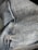 Close-up view of denim fabric showcasing the texture and stitching details. The fabric appears to be part of a garment, possibly jeans, with visible seams and traditional blue coloration.