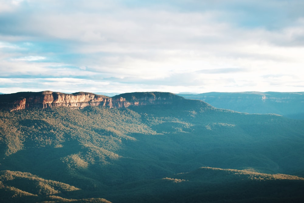 green and brown mountains under white clouds during daytime