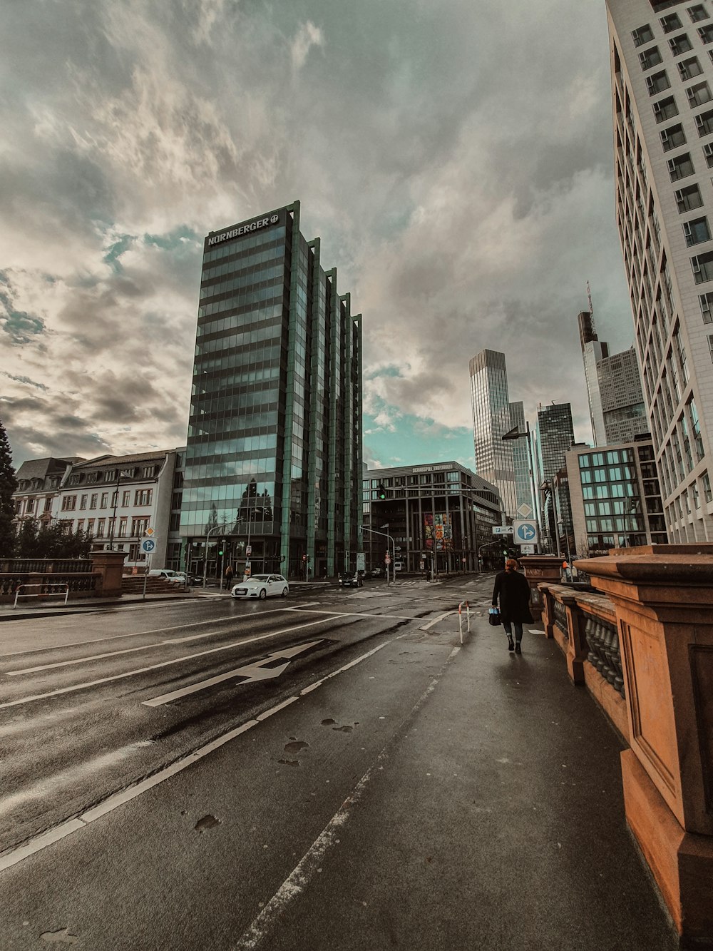 people walking on sidewalk near high rise buildings during daytime