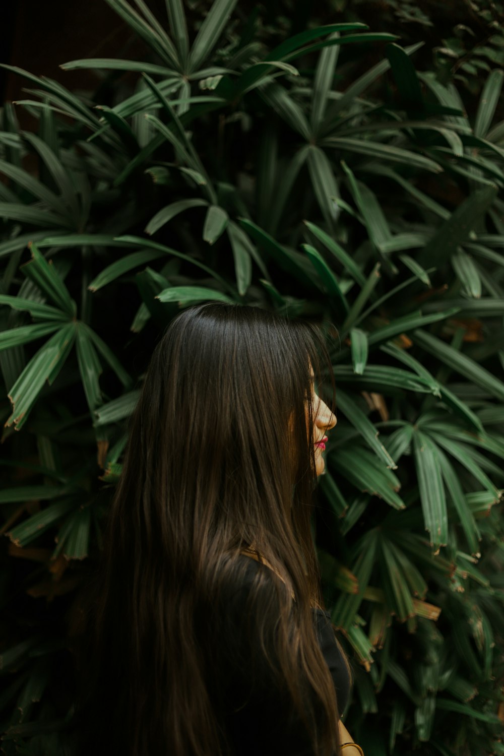 woman with black hair covering her face with her hair