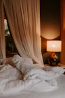 Cozy bedroom corner with soft linens and warm lighting creating a relaxing atmosphere.