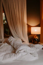 Cozy bedroom corner with soft linens and warm lighting creating a relaxing atmosphere.