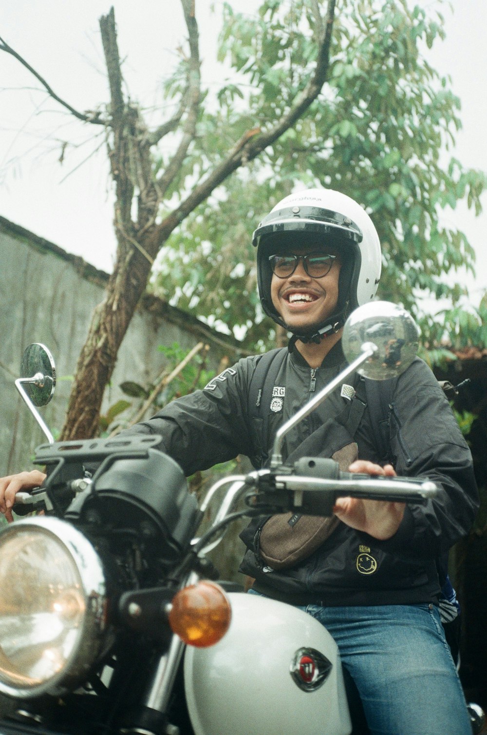 Mann in schwarzer Lederjacke mit Helm Motorradfahren tagsüber