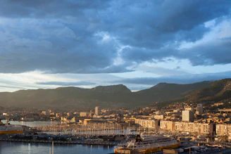 city buildings near body of water under cloudy sky during daytime