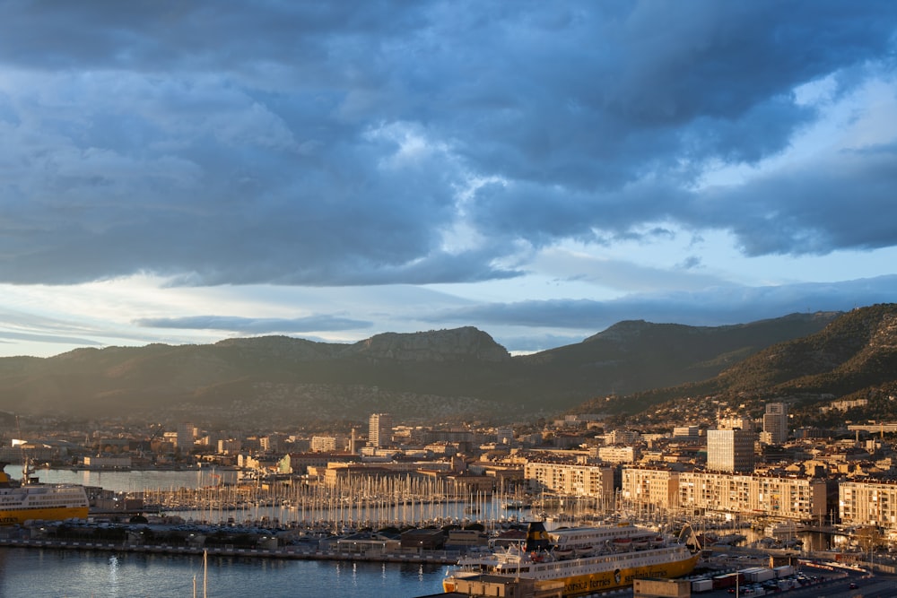 city buildings near body of water under cloudy sky during daytime