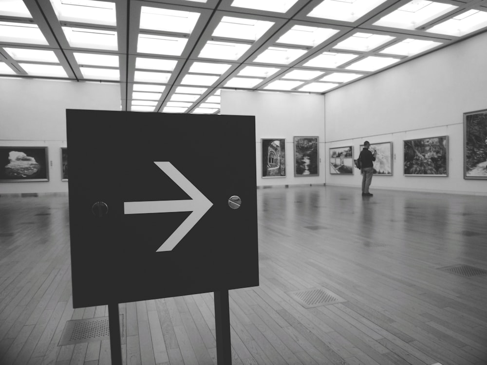 grayscale photo of people walking on hallway