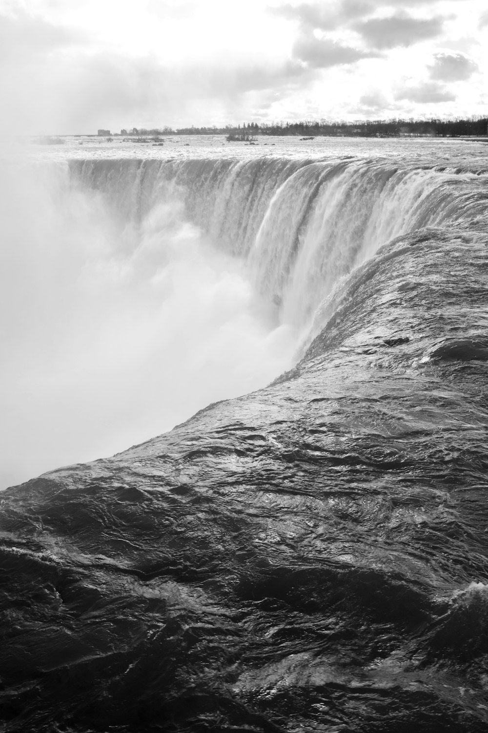 grayscale photo of waterfalls in the middle of the forest