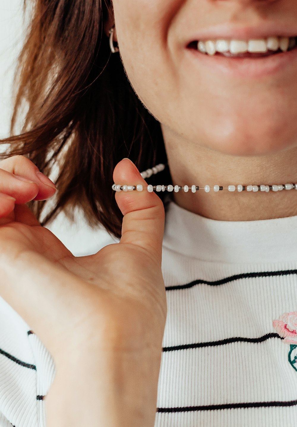 woman in white shirt wearing silver necklace