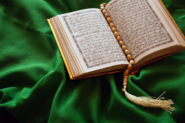 An open Qur'an resting on a wooden stand.