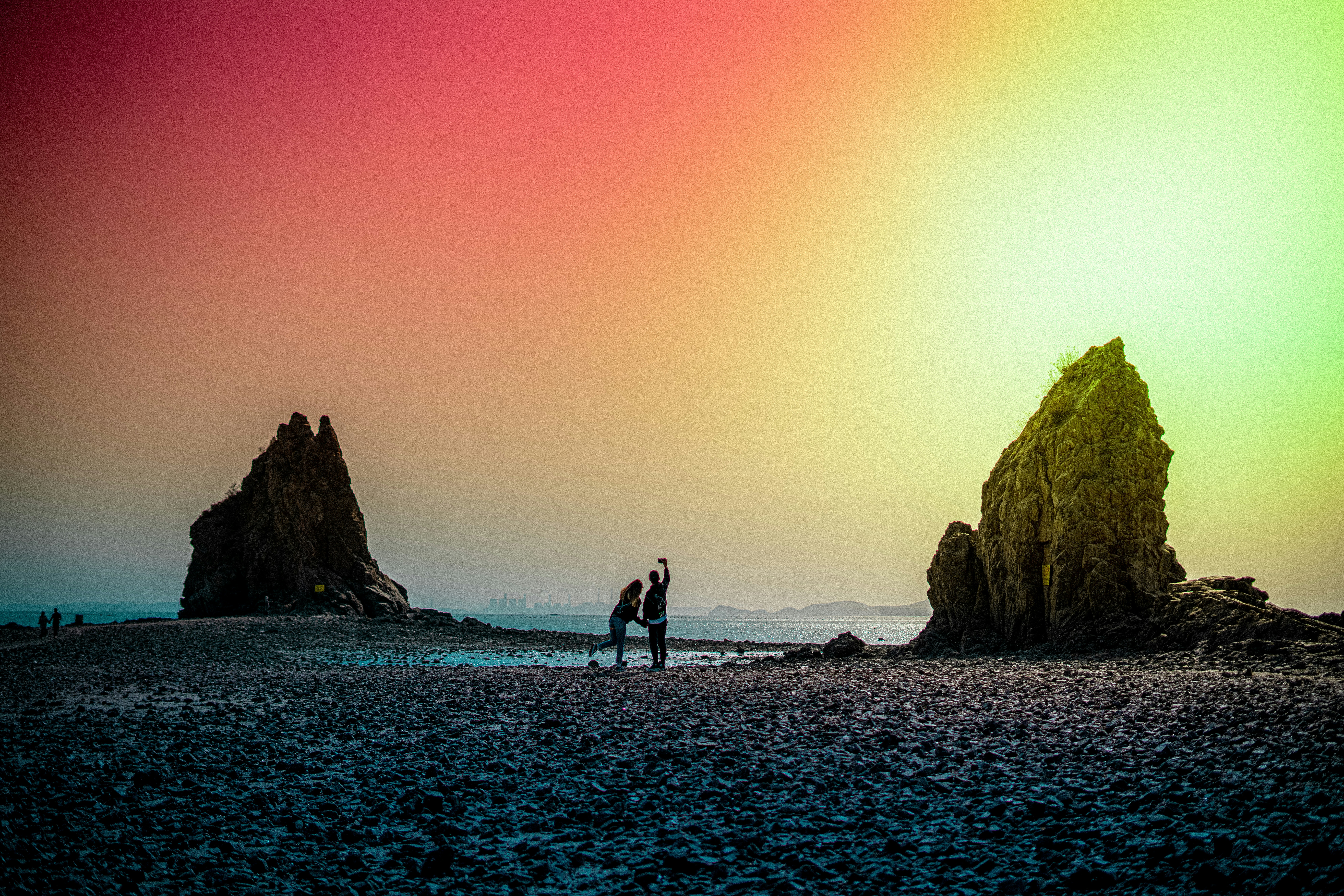 homem e mulher que caminham na praia durante o pôr do sol
