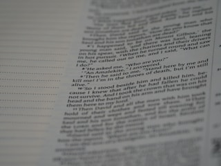 A close-up view of a page from a book, featuring text in a serif font. The text appears to be a narrative or dialogue, with numbered lines and a clear structure. The background is a pale color, likely the paper of the book.