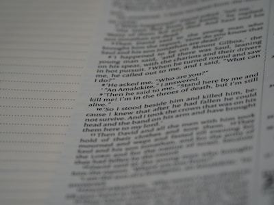 A close-up view of a page from a book, featuring text in a serif font. The text appears to be a narrative or dialogue, with numbered lines and a clear structure. The background is a pale color, likely the paper of the book.