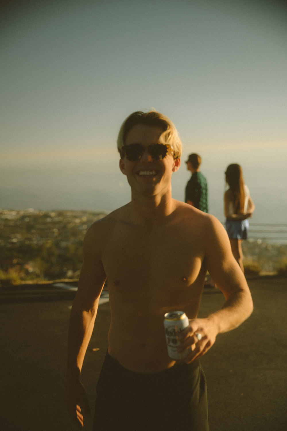 topless man holding clear glass cup