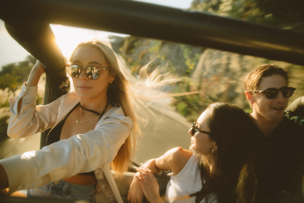 Mujer en chaqueta blanca y gafas de montura negra sentada al lado de mujer en gafas de montura negra durante