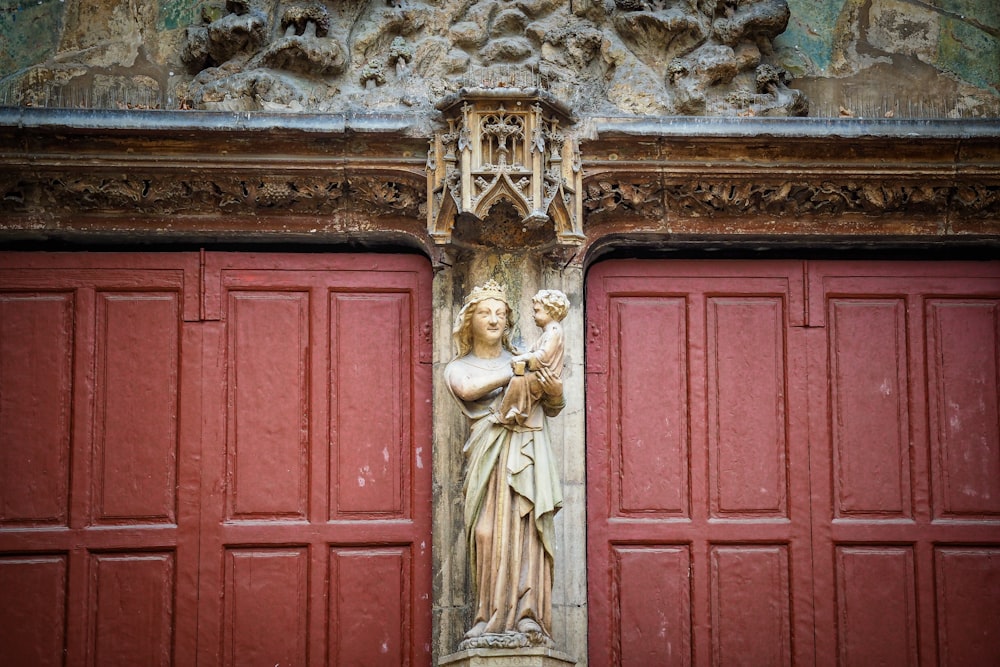 red wooden door with angel statue