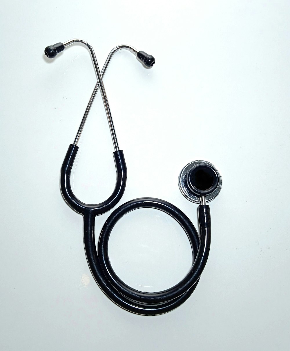 black and silver stethoscope on white surface