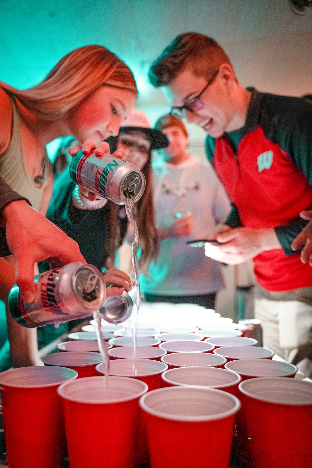 man in red polo shirt pouring wine on clear wine glass