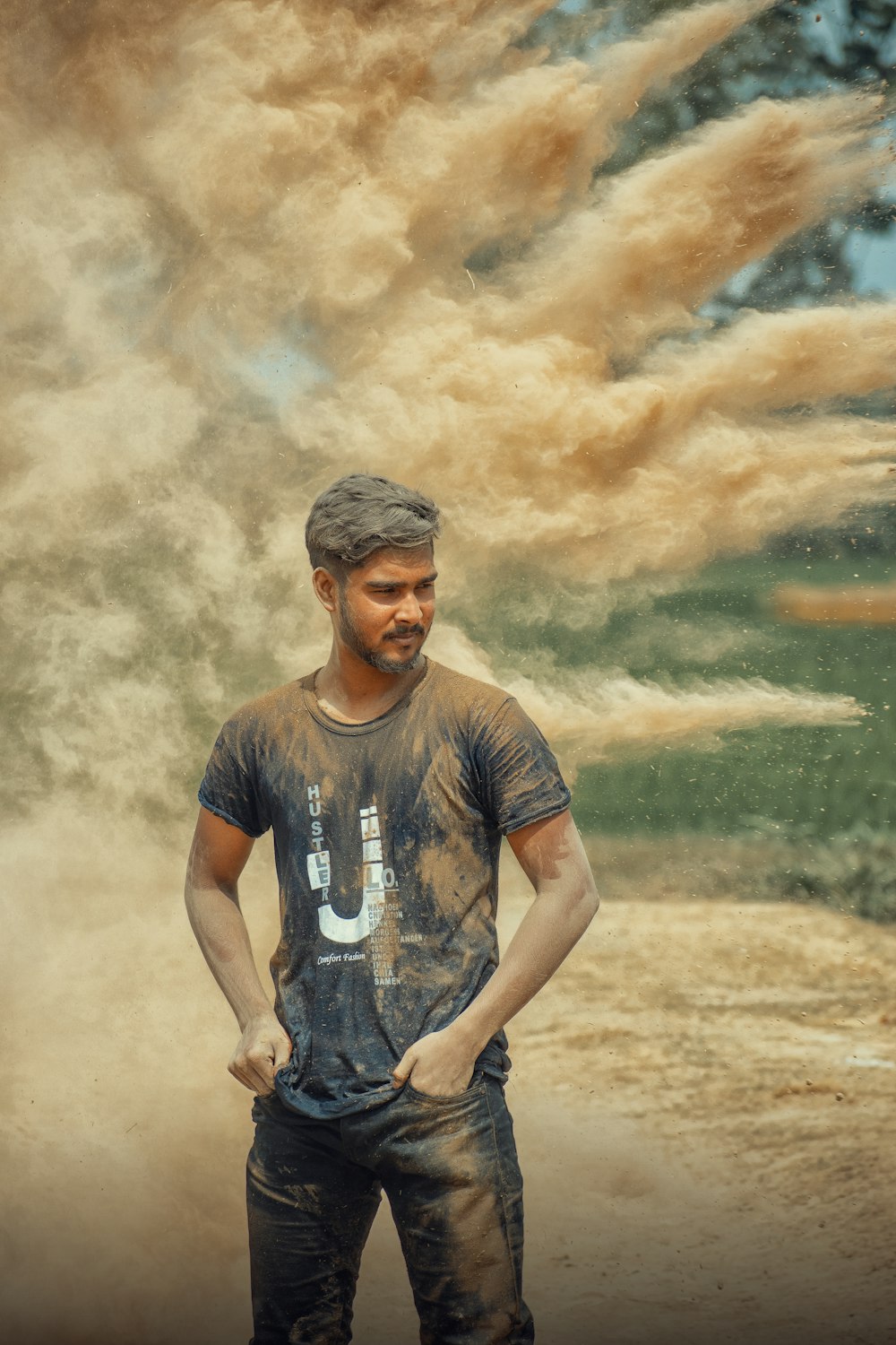 man in black crew neck t-shirt standing on brown field