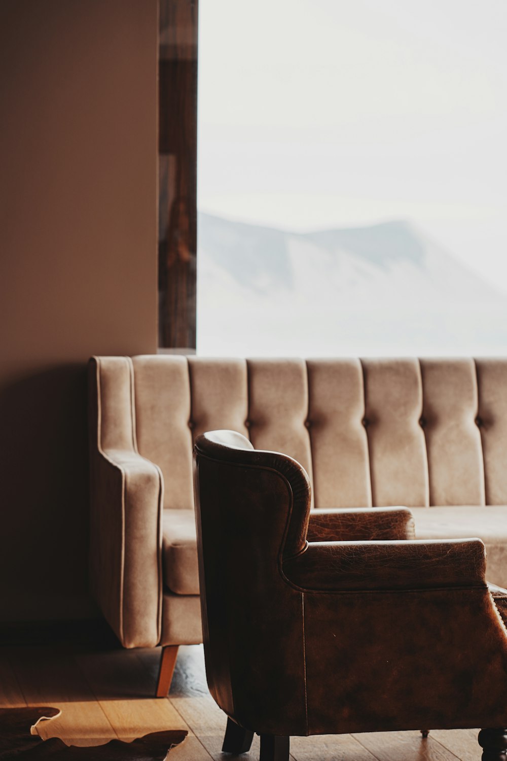 brown wooden framed white padded armchair