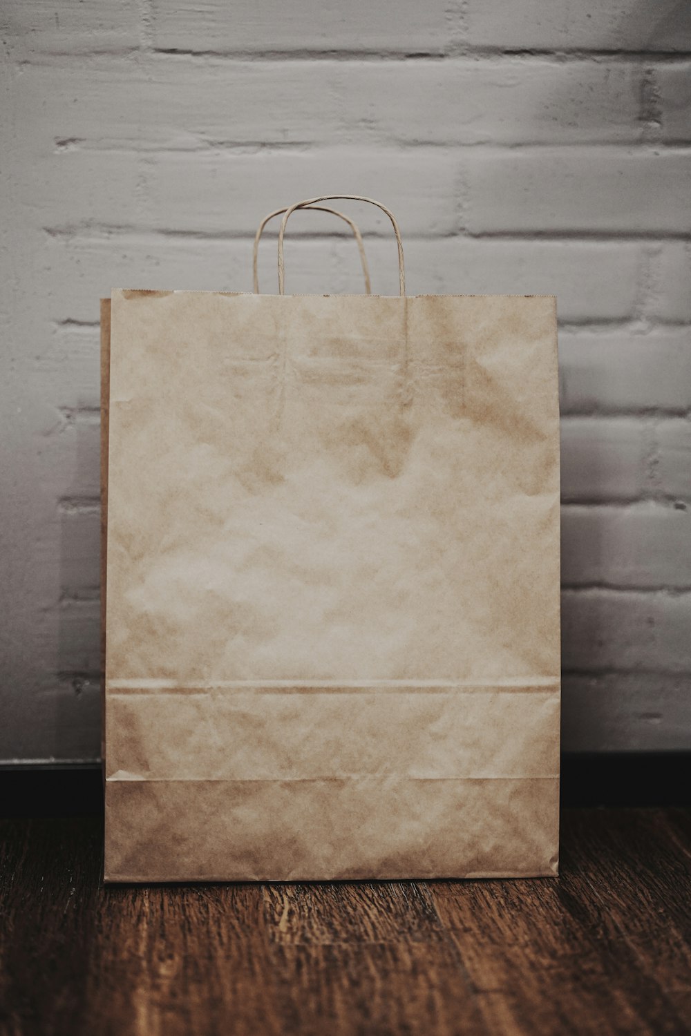 brown paper bag on white textile