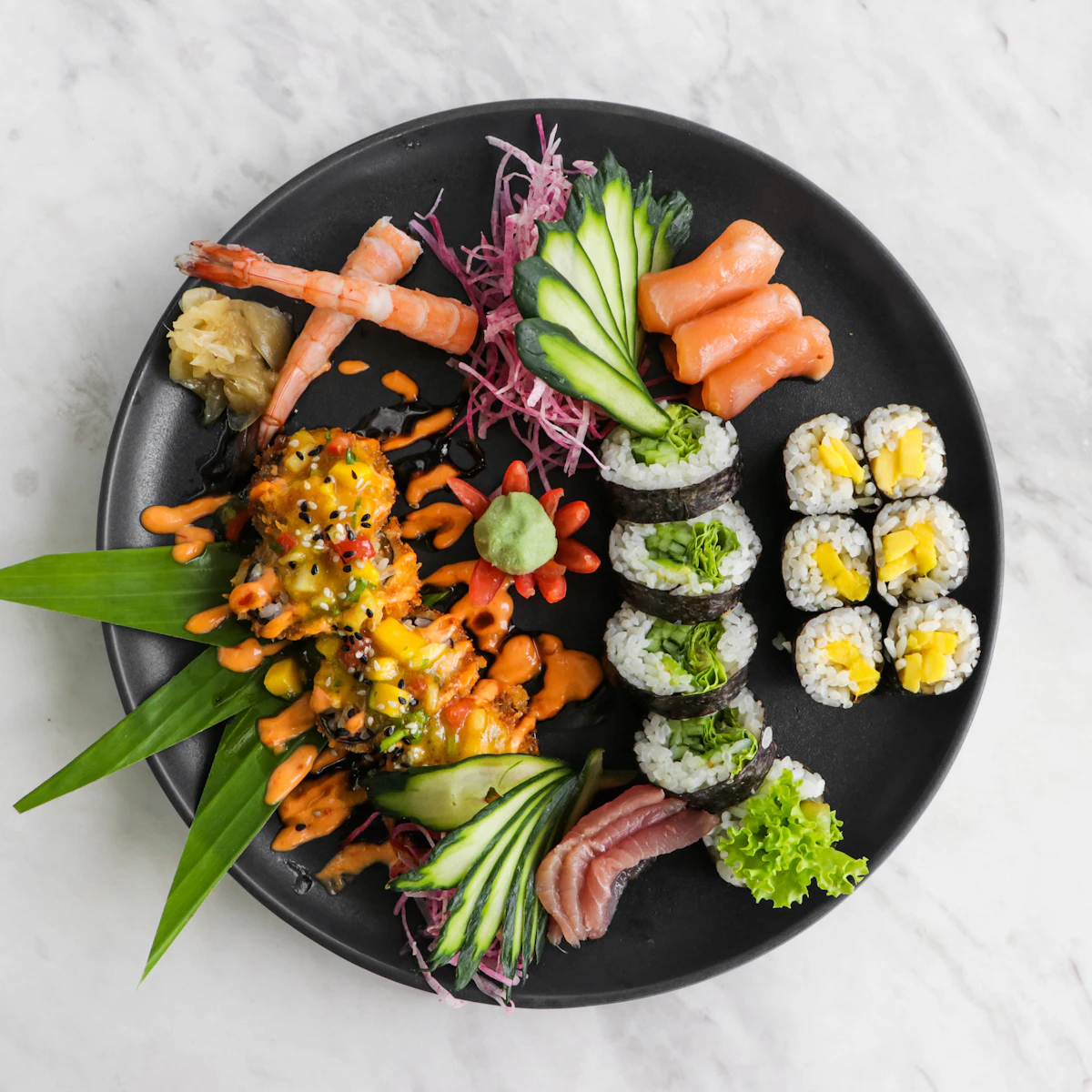 A platter of fresh raw fish sashimi on a black plate