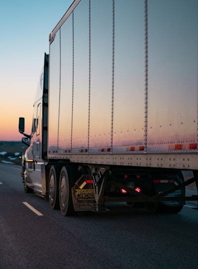 white freight truck on road during daytime