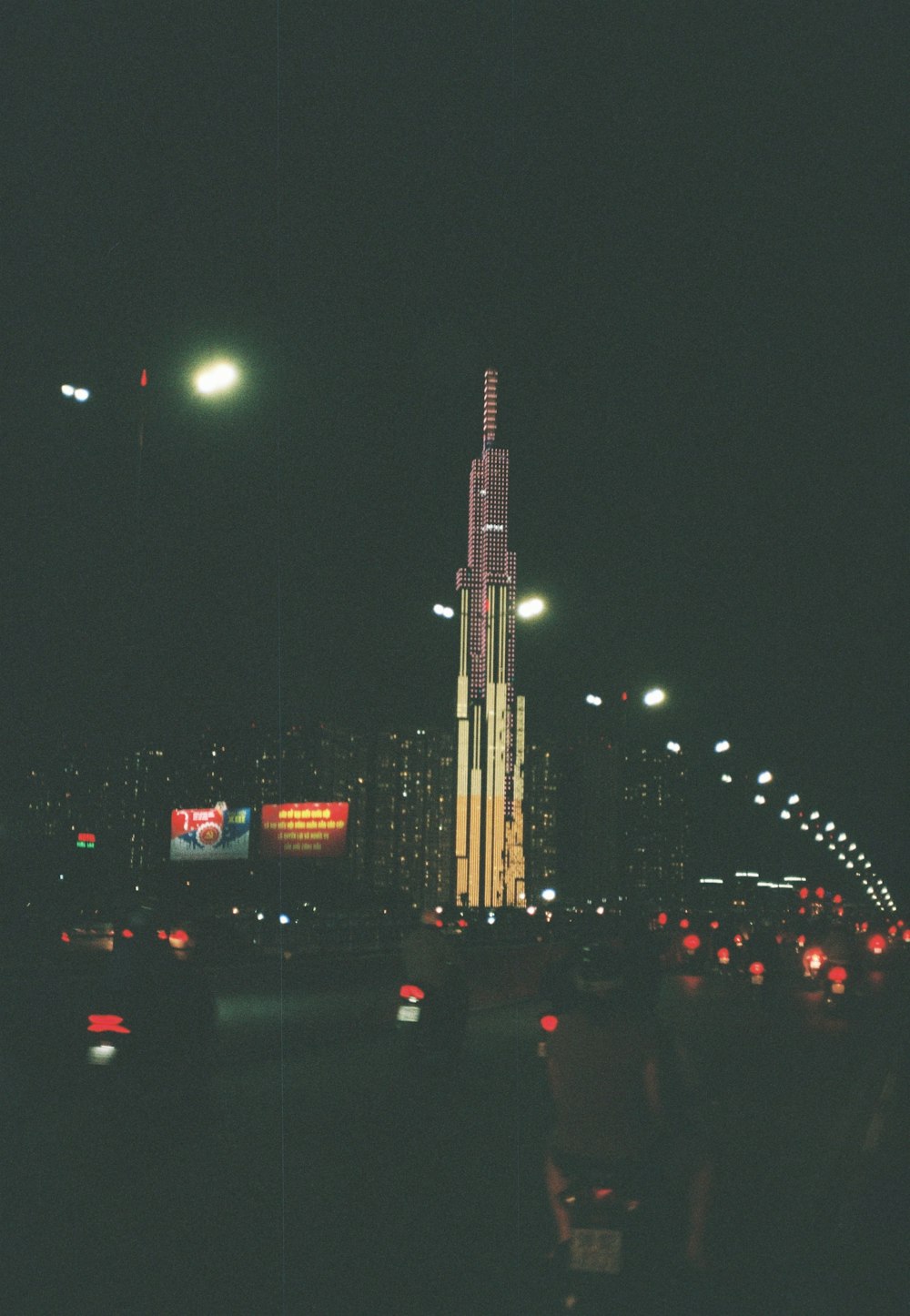 cars on road near high rise buildings during night time