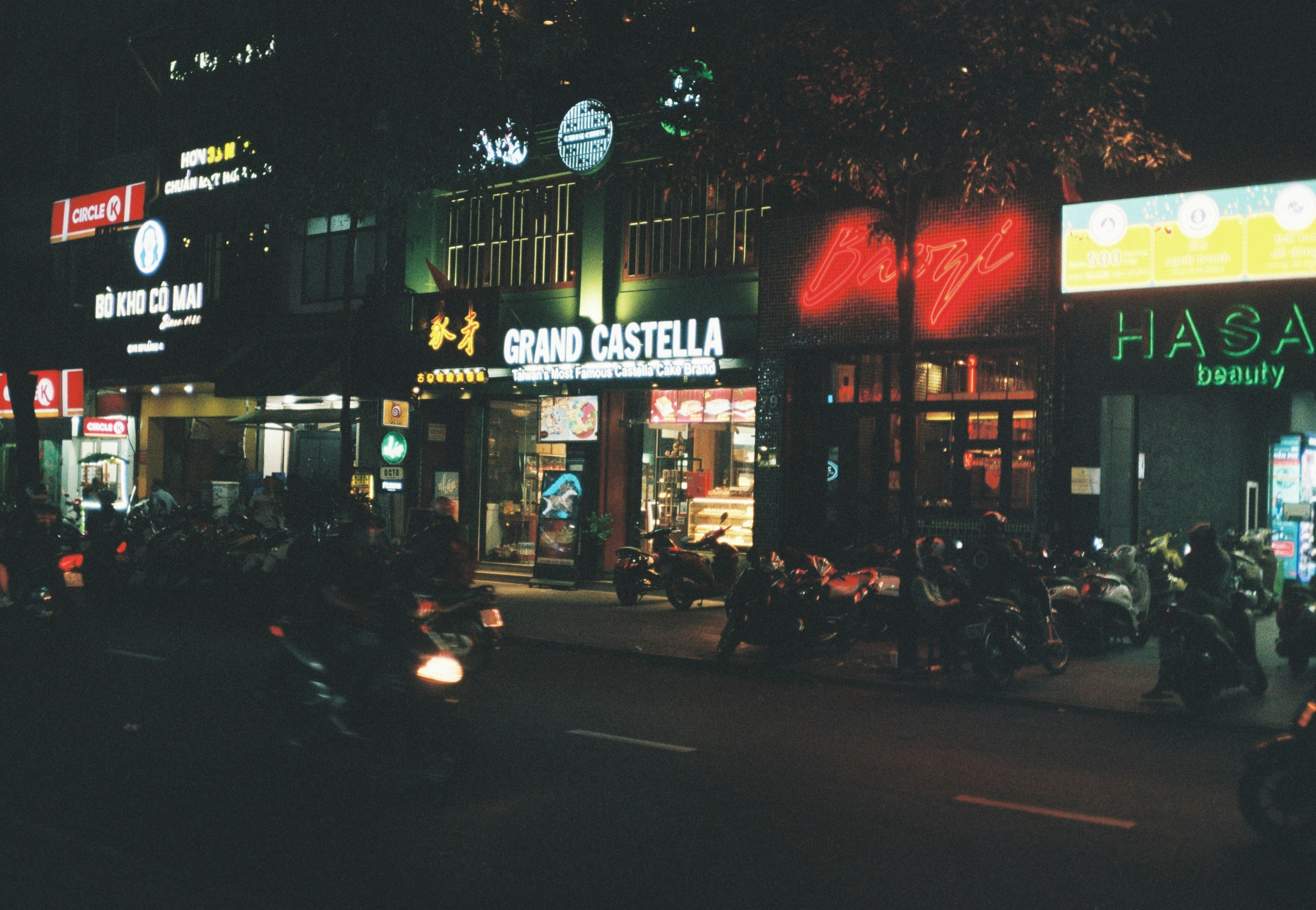 people walking on sidewalk near store during night time