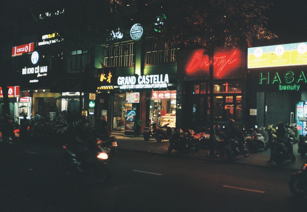 people walking on sidewalk near store during night time